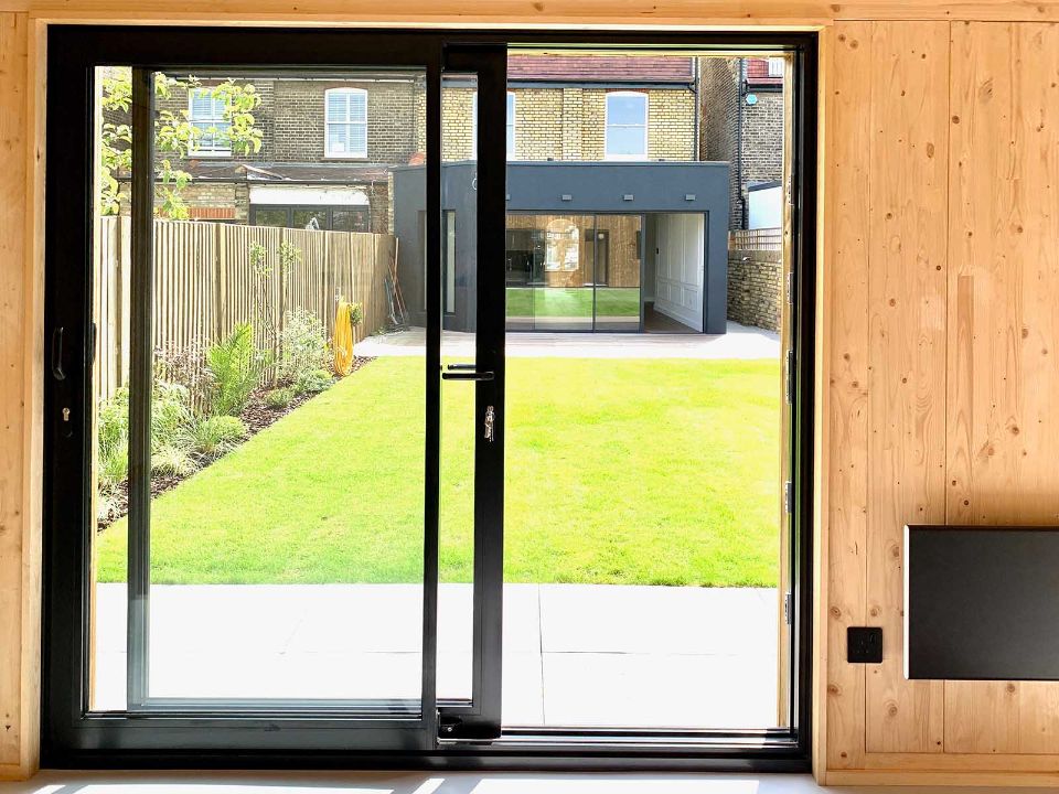 black framed sliding door overlooking the garden area