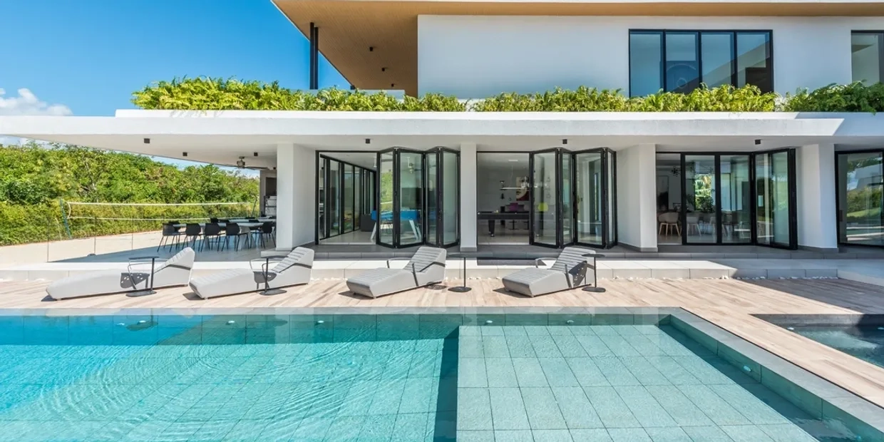 modern two storey home with large black bifold doors opening onto a swimming pool
