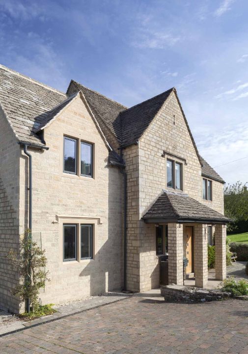 cottage with multiple green framed aluminium windows
