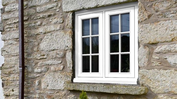 white framed wooden flush windows installed at the house exterior