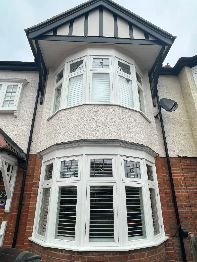 white uPVC bay windows installed on a two storey brick and pebble dash house