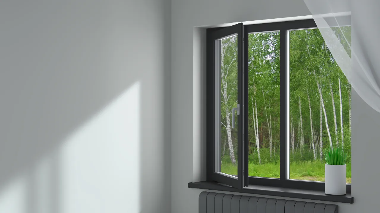 black framed casement window partially open, overlooking a green forest with white birch trees